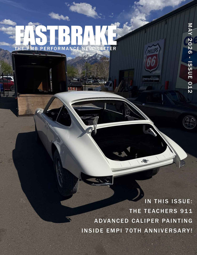 White long-hood Porsche 911 restoration body outside the PMB Performance shop featured on the May 2026 FastBrake newsletter cover discussing The Teacher’s 911 project, advanced caliper painting, and EMPI’s 70th anniversary