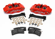 Wilwood red rear Superlite caliper kit laid out with mounting brackets, shims, fasteners and brake pads
