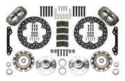 Wilwood Dynapro brake kit: Two gray anodized Dynapro calipers, thin drilled rotors, round rotor adapters, aluminum hubs, bearings, pads, spindle brackets and fasteners arranged as a parts layout; 10.75-inch front brake setup for Later GM Disc Spindle.