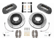 Wilwood TX6R brake kit: Pair of gray anodized TX6R calipers, slotted rotors with integral black hats, pads, braided hoses, brackets and fasteners laid out; 15.5-inch rear brake setup for Super Duty 4WD SRW.