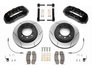 Wilwood TX6R brake kit: Pair of black TX6R calipers, slotted rotors with integral black hats, pads, braided hoses, brackets and fasteners laid out; 15.5-inch rear brake setup for Super Duty 4WD SRW.