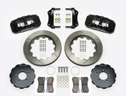 Wilwood AERO6 brake kit: Two black calipers, slotted rotor rings, separate dark hats, pads, brackets, centering rings and fasteners laid out; no hoses visible; 14-inch front brake setup for Ford Panther Cars.
