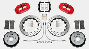 Wilwood Superlite 4R brake kit: Pair of red calipers, drilled-and-slotted rotor rings, hats with their inner faces visible, pads, hoses, brackets and mounting fasteners arranged on white; 12.88-inch rear brake setup for BMW E46 M3.
