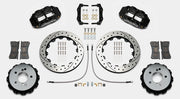 Wilwood Superlite 4R brake kit: Pair of black calipers, drilled-and-slotted rotor rings, hats with their inner faces visible, pads, hoses, brackets and mounting fasteners arranged on white; 12.88-inch rear brake setup for BMW E46 M3.