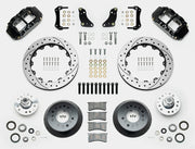 Wilwood Superlite 6R brake kit: Two black calipers, drilled-and-slotted rotor rings, deep dark hats, separate aluminum hubs, bearings, pads, mounting brackets, wheel studs and fasteners in a layout; 12.88-inch front brake setup for 1957–1967 F-100.