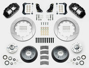 Wilwood Superlite 6R brake kit: Two black calipers, slotted rotor rings, deep dark hats, separate aluminum hubs, bearings, pads, mounting brackets, wheel studs and fasteners in a layout; 14-inch front brake setup for 1957–1967 F-100.