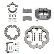 Wilwood sprint rear kit laid out with a gray four-piston caliper, scalloped Super Alloy vented rotor, splined axle clamp, adapter, pads and bracket