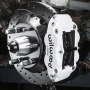Wilwood six-lug GM truck front installation reference with white Superlite caliper and drilled/slotted rotor; supplied kit is black with 14-inch GT rotors.