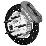 Wilwood front gray Dynalite caliper beside a 10.75-inch drilled rotor, angled assembly for GM G-body/S10 spindle arrangement
