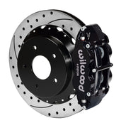 Wilwood rear black Superlite 4R caliper beside a 12.88-inch drilled/slotted rotor, angled assembly for Corvette C2/C3 original parking mechanism