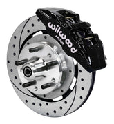 Wilwood front black Dynapro 6 caliper beside a 12.19-inch drilled/slotted rotor, angled assembly for GM/Ford pin-spindle six-piston setup