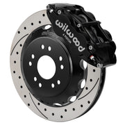 Wilwood front black Superlite 6R caliper beside a 13.06-inch drilled/slotted rotor, angled assembly for Corvette C2/C3 front hub setup