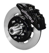 Wilwood front black Dynapro 6 caliper beside a 12.19-inch plain-face rotor, angled assembly for Tri-Five Chevrolet drum spindle