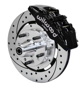 Wilwood front black Dynapro 6 caliper beside a 12.19-inch drilled/slotted rotor, angled assembly for GM 11-inch-spindle Dynapro conversion