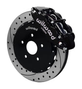 Wilwood front black Superlite 6R caliper beside a 12.88-inch drilled/slotted rotor, angled assembly for Matrix FWD 2.4L front hub