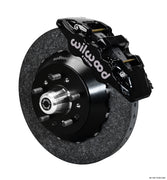 Wilwood ProSpindle carbon-ceramic front single-side assembly with a black AERO6 caliper beside the carbon-ceramic rotor and protruding wheel studs