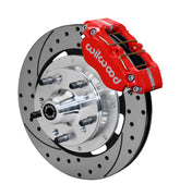 Wilwood GM and Ridetech pin-spindle front single-side assembly showing a red Dynapro dust-boot caliper beside a 12.19-inch drilled-and-slotted rotor and protruding wheel studs