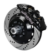 Wilwood TCI IFS front single-side assembly with a black Aero6 caliper beside the drilled-and-slotted rotor and protruding wheel studs
