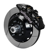 Wilwood TCI IFS front single-side assembly with a black Aero6 caliper beside the slotted rotor ring and protruding wheel studs