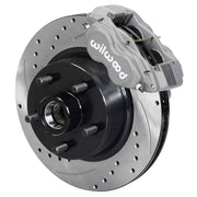 Wilwood later Ford/Mercury front Dynalite-M brake kit assembly example, showing an anodized caliper positioned over the drilled and slotted rotor/hub