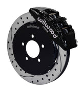 Wilwood Mazda 3 front Dynapro 6 brake kit assembly example, showing a black caliper positioned over the drilled and slotted rotor and mounting hat
