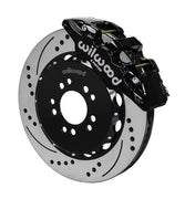 Wilwood Corvette C7 front AERO6 brake kit assembly example, showing a black caliper positioned over the drilled and slotted rotor and mounting hat