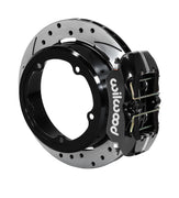 Wilwood black low-profile rear caliper beside an assembled drilled-and-slotted rotor with a deep parking-brake hat