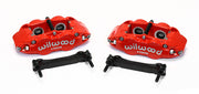 Wilwood pair of red four-piston rear calipers beside two mounting brackets; no rotors shown