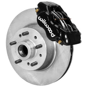Wilwood black four-piston front caliper beside a plain vented rotor with an integral wheel hub and studs