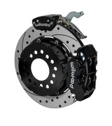 Wilwood black Dynalite service caliper and MC4 parking caliper around a 12.19-inch drilled-and-slotted rotor, shown for modified GM 12-bolt axles with nonstaggered shocks