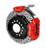 Wilwood red Dynalite service caliper and MC4 parking caliper around a 12.19-inch drilled-and-slotted rotor, shown for modified GM 12-bolt axles with nonstaggered shocks