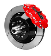Wilwood red Superlite front caliper over a slotted rotor assembly with a projecting hub and wheel studs