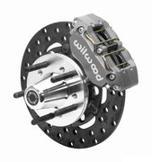 Wilwood Dynapro brake kit: An anodized Dynapro caliper beside a thin drilled rotor and aluminum hub with five protruding wheel studs; 10.75-inch front brake setup for Dodge/Plymouth B/E.