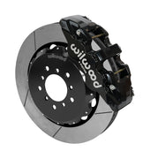 Wilwood AERO6 brake kit: A black caliper beside a slotted rotor mounted to a black five-hole hat, viewed at an angle; 14-inch front brake setup for BMW E46 M3.