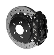 Wilwood Superlite 4R brake kit: A black caliper beside a drilled-and-slotted rotor mounted to a black five-hole hat, viewed at an angle; 12.88-inch rear brake setup for BMW E46 M3.