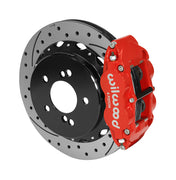Wilwood Superlite 4R brake kit: A red caliper beside a drilled-and-slotted rotor mounted to a black five-hole hat, viewed at an angle; 12.88-inch rear brake setup for BMW E46 M3.