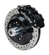 Wilwood Superlite 6R brake kit: A black caliper beside a drilled-and-slotted rotor and deep black hat over a wheel hub, with visible studs and a polished dust cap; 12.88-inch front brake setup for 1957–1967 F-100.