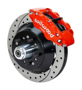 Wilwood Superlite 6R brake kit: A red caliper beside a drilled-and-slotted rotor and deep black hat over a wheel hub, with visible studs and a polished dust cap; 12.88-inch front brake setup for 1957–1967 F-100.