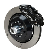 Wilwood Superlite 6R brake kit: A black caliper beside a slotted rotor and deep black hat over a wheel hub, with visible studs and a polished dust cap; 14-inch front brake setup for 1957–1967 F-100.
