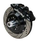 Wilwood AERO6 brake kit: A black caliper beside a drilled-and-slotted rotor and deep black hat over a wheel hub, with visible studs and a polished dust cap; 14-inch front brake setup for 1957–1967 F-100.
