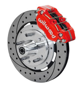 Wilwood red four-piston front caliper beside a 12.19-inch drilled-and-slotted rotor with projecting wheel hub for the 1970–1974 Ford/Mercury spindle installation