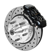 Wilwood black four-piston front caliper beside an 11-inch drilled-and-slotted rotor with projecting wheel hub for the early A-body 11-inch front installation