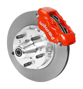 Wilwood red four-piston front caliper beside an 11-inch plain-face rotor with projecting wheel hub for the early A-body 11-inch front installation