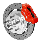 Wilwood red four-piston front caliper beside a 12.19-inch drilled-and-slotted rotor with projecting wheel hub for the early A-body 12.19-inch front installation