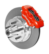 Wilwood red four-piston front caliper beside an 11-inch plain-face rotor with projecting wheel hub for the later Mopar 11-inch front installation