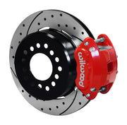 Wilwood red D154 rear caliper beside an assembled 12.19-inch drilled-and-slotted parking-hat rotor for the GM 12-bolt forward-caliper rear interface