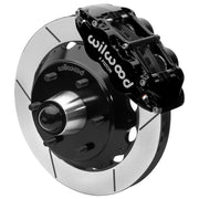 Wilwood black front caliper beside the assembled 13.06-inch slotted rotor for the Chevrolet/GMC six-lug 13.06-inch Superlite drop-spindle brake conversion, with the hub and wheel studs visible
