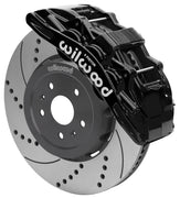 Wilwood front SX6R brake kit for Corvette C8: Black SX6R caliper over a drilled and slotted rotor and silver center hat in an assembled brake view.