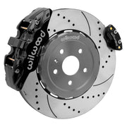 Wilwood rear AERO4 brake kit for Corvette C8 service and parking brakes: Assembled drilled and slotted rotor with a black AERO4 caliper and a separate matching parking caliper on the opposite edge.