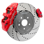 Wilwood rear AERO4 brake kit for Corvette C8 service and parking brakes: Assembled drilled and slotted rotor with a red-finish AERO4 caliper and a separate matching parking caliper on the opposite edge.